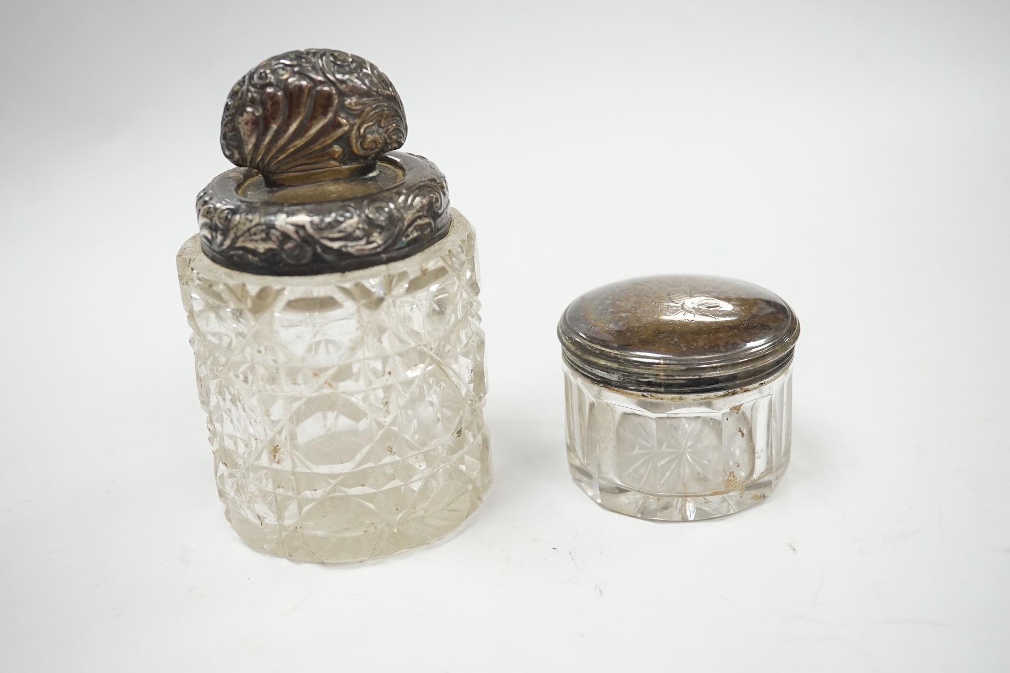 A quantity of assorted small silver including a George III cream jug(a.f.), three small capstan inkwells, a watch stand, photograph frame, mounted glass toilet jars etc. Condition - poor to fair